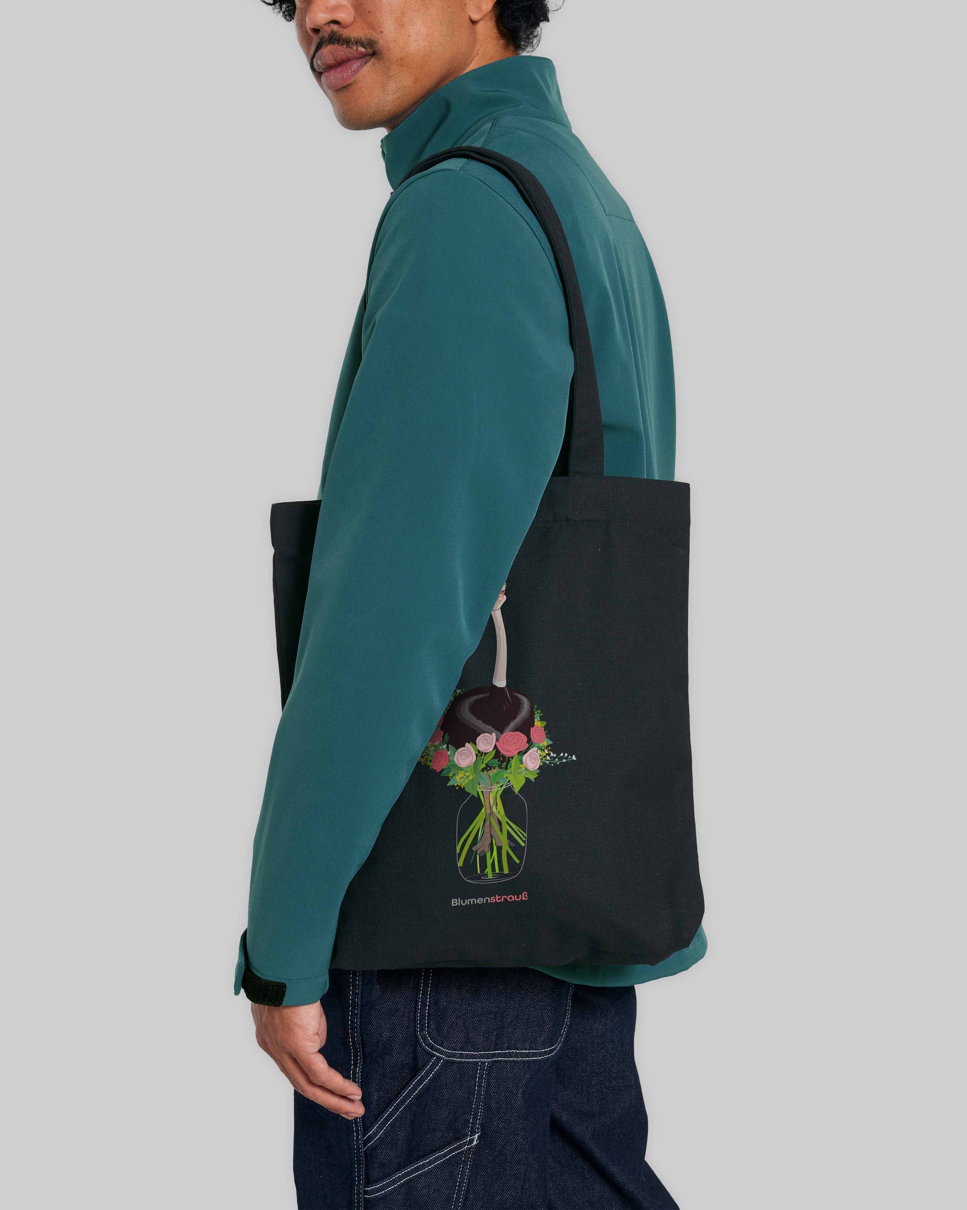 EINHORST® Stofftasche in Schwarz mit dem Motiv "Blumenstrauß", Bild von männlicher Person mit Stofftasche unter dem Arm