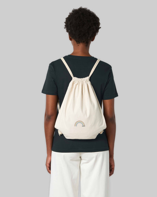 EINHORST® Sportbeutel in "Neutral" mit dem Motiv "queer Regenbogen" in der Kombination bunter Regenbogen mit schwarzer Schrift, Bild von männlicher Person mit Sportbeutel