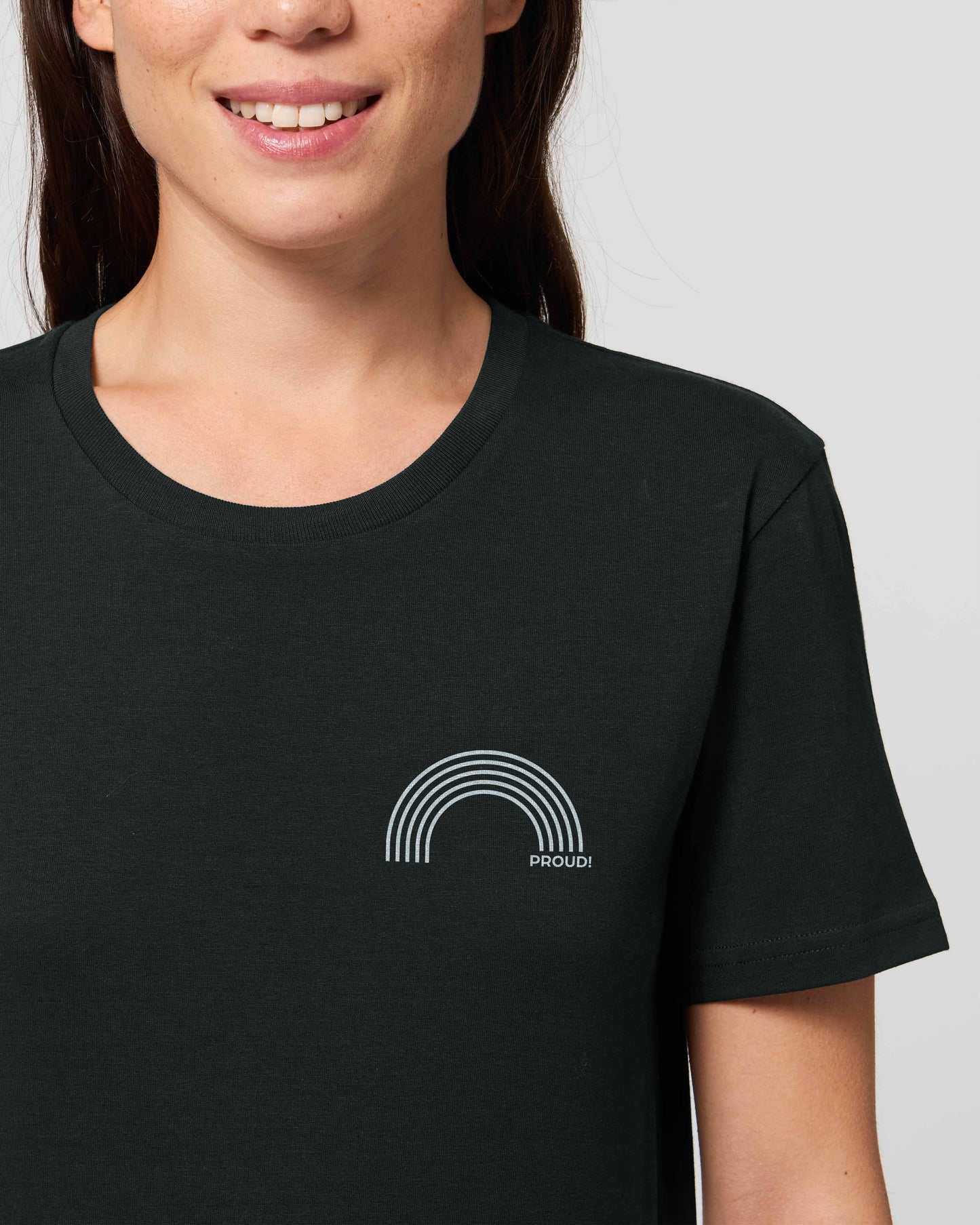 EINHORST® unisex Organic Shirt in Schwarz mit dem Motiv "proud Regenbogen" in der Kombination weißer Regenbogen mit weißer Schrift, Bild von weiblicher Person mit Shirt