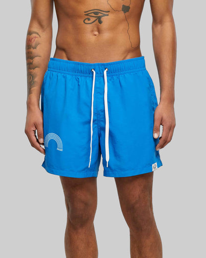 EINHORST® Schwimm- & Sportshorts mit dem Motiv "pride-Regenbogen" in der Farbe "Cobald Blue", Bild von einer männlichen Person von vorne, die die Shorts trägt